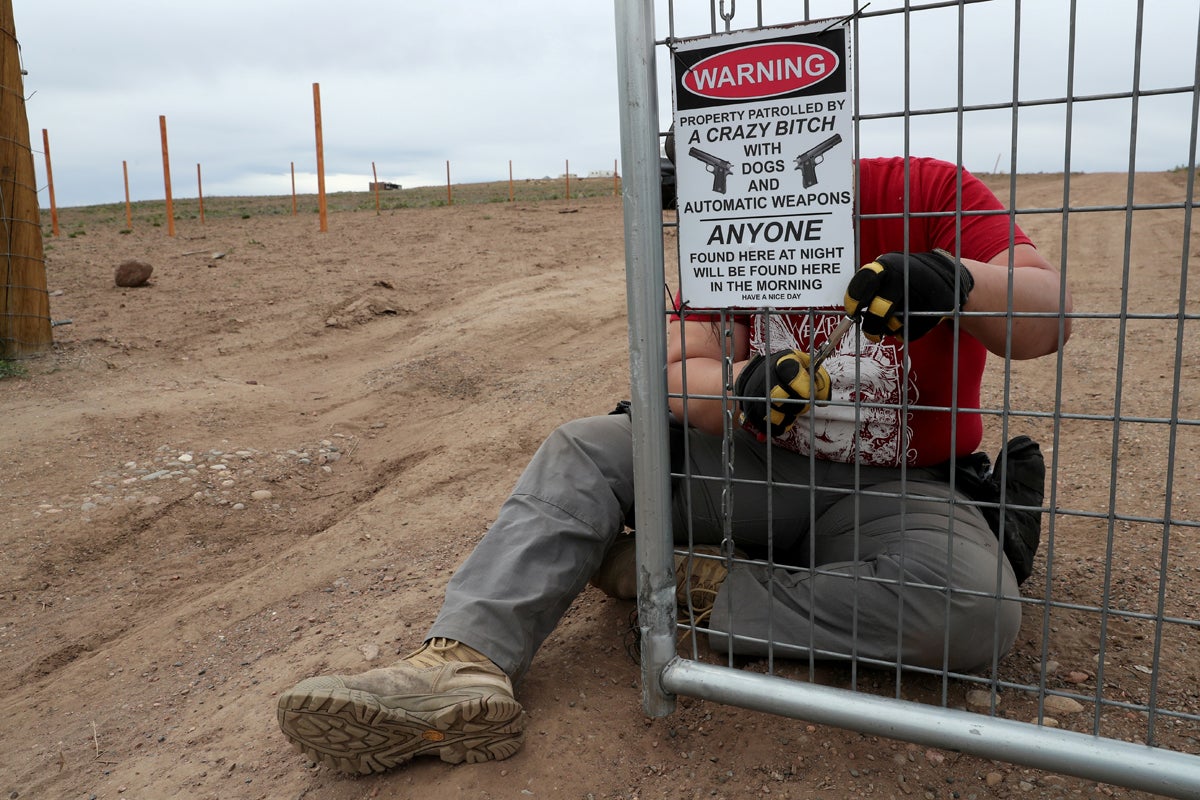 Bonnie Nelson, 34, puts up a warning sign on the front gate of the Tenacious Unicorn Ranch