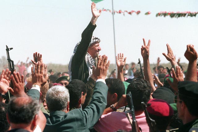 <p>PLO chairman Yasser Arafat waves to a crowd of cheering Palestinians after he crossed the Rafah border point on 1 July 1994, entering the newly self-ruled Gaza Strip for the first time in 27 years</p>