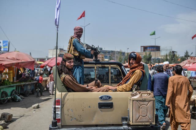 <p>Taliban fighters on a pick-up truck move around a market area, flocked with local Afghan people at the Kote Sangi area of Kabul on August 17, 2021, after Taliban seized control of the capital following the collapse of the Afghan government</p>