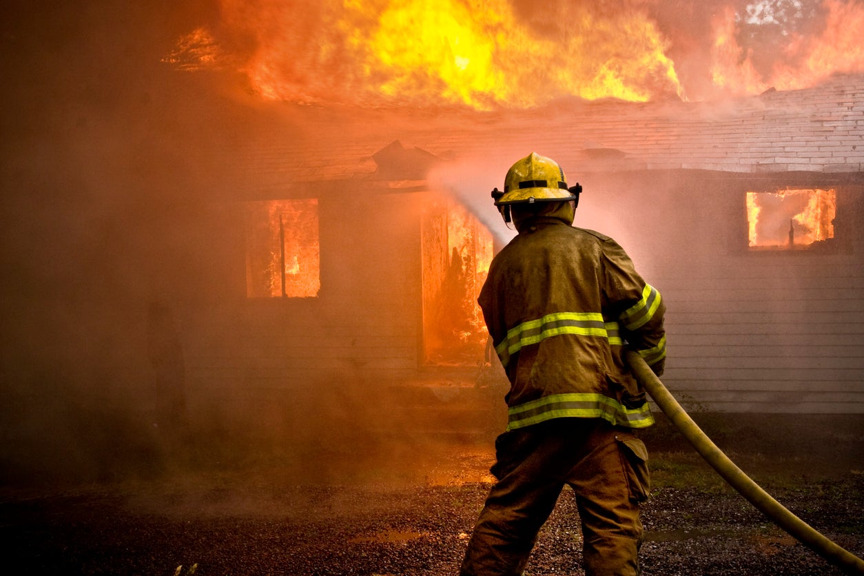 A fireman attempts to stop a house from burning down (file photo)