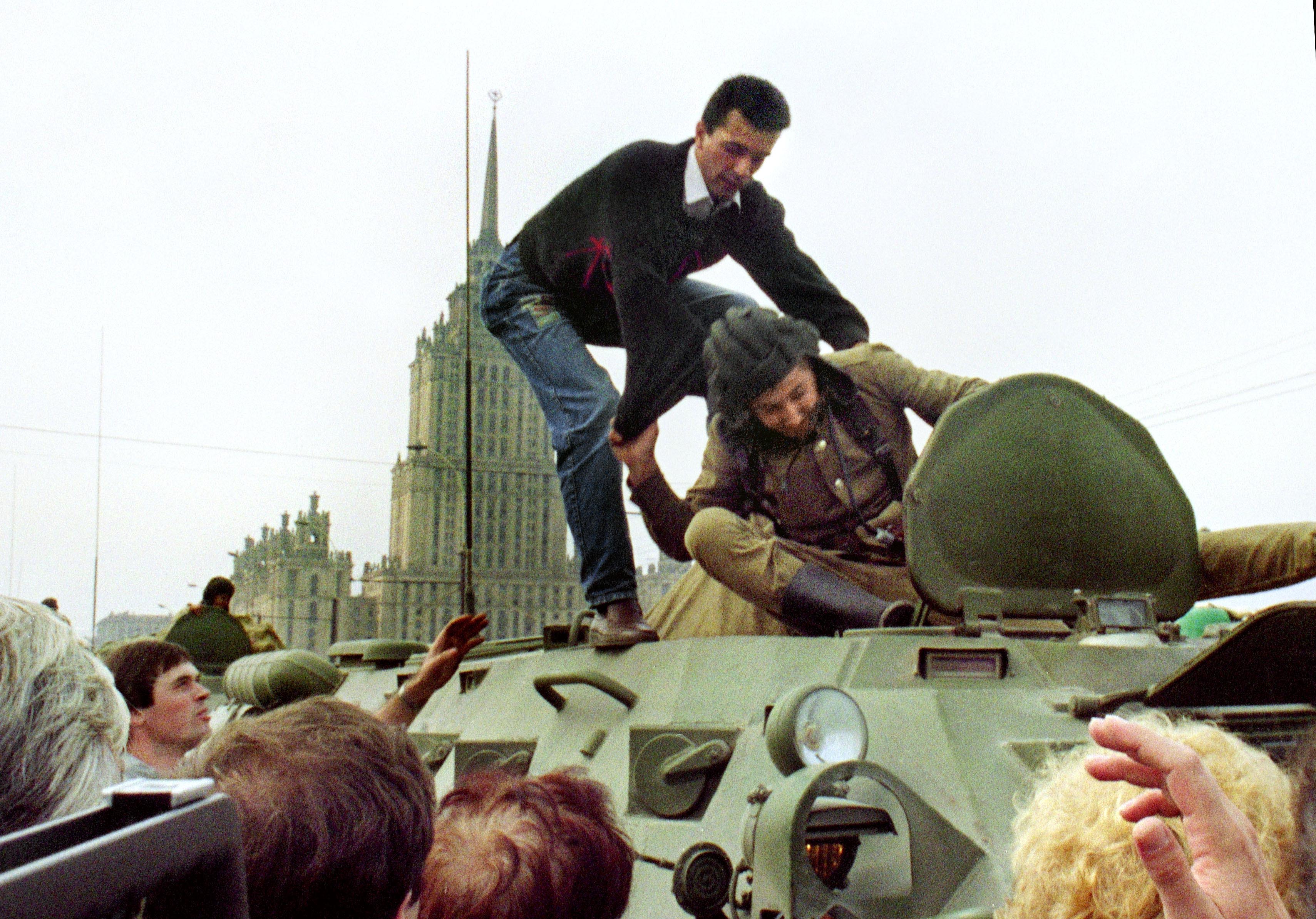 A pro-democracy demonstrator fights with a Soviet soldier on top of a tank parked in front of the Russian Federation building on 19 August 1991