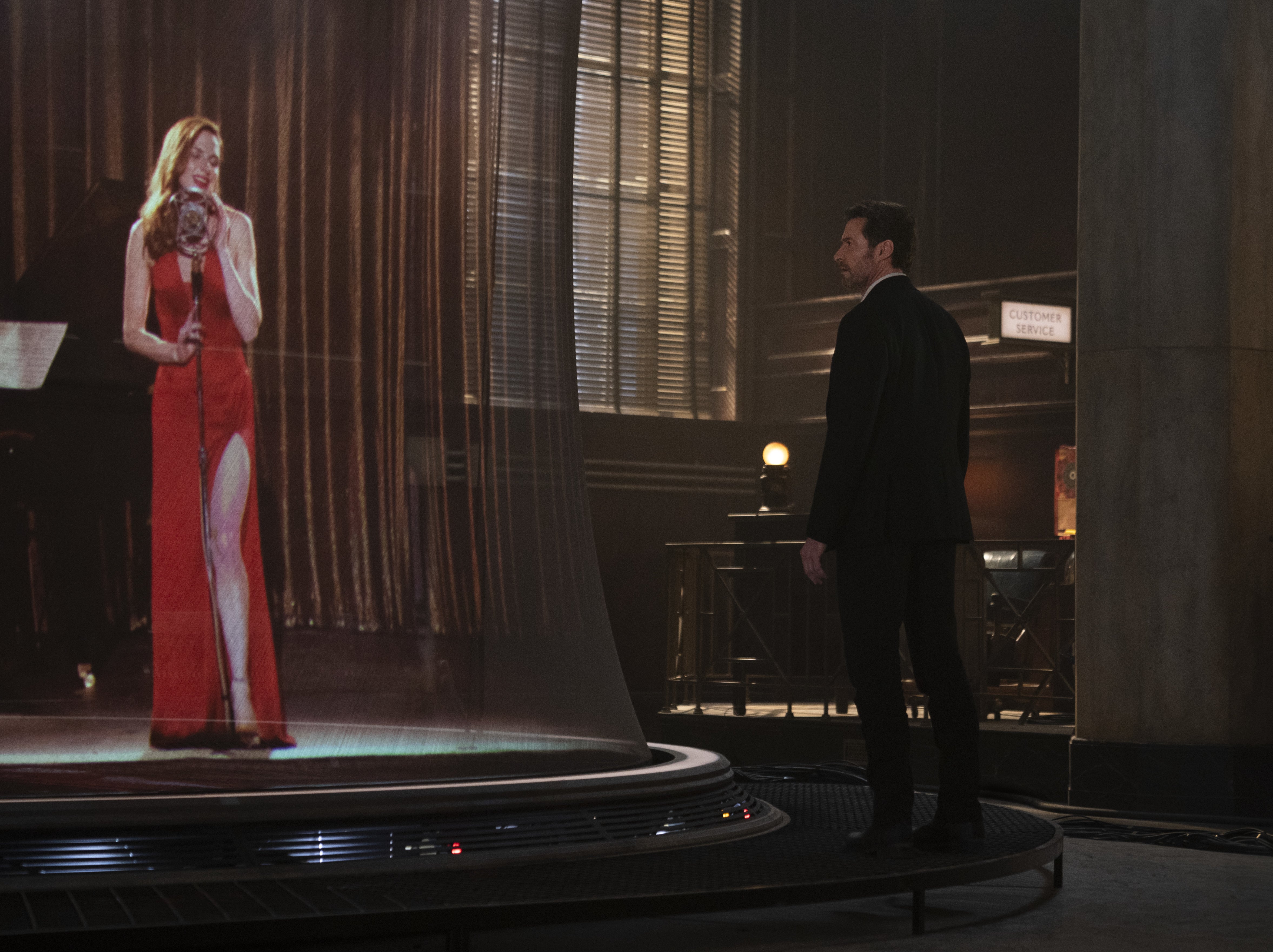 We learn Mae (Rebecca Ferguson) is a chanteuse and, perfectly on cue, she steps out in a va va voom Jessica Rabbit dress