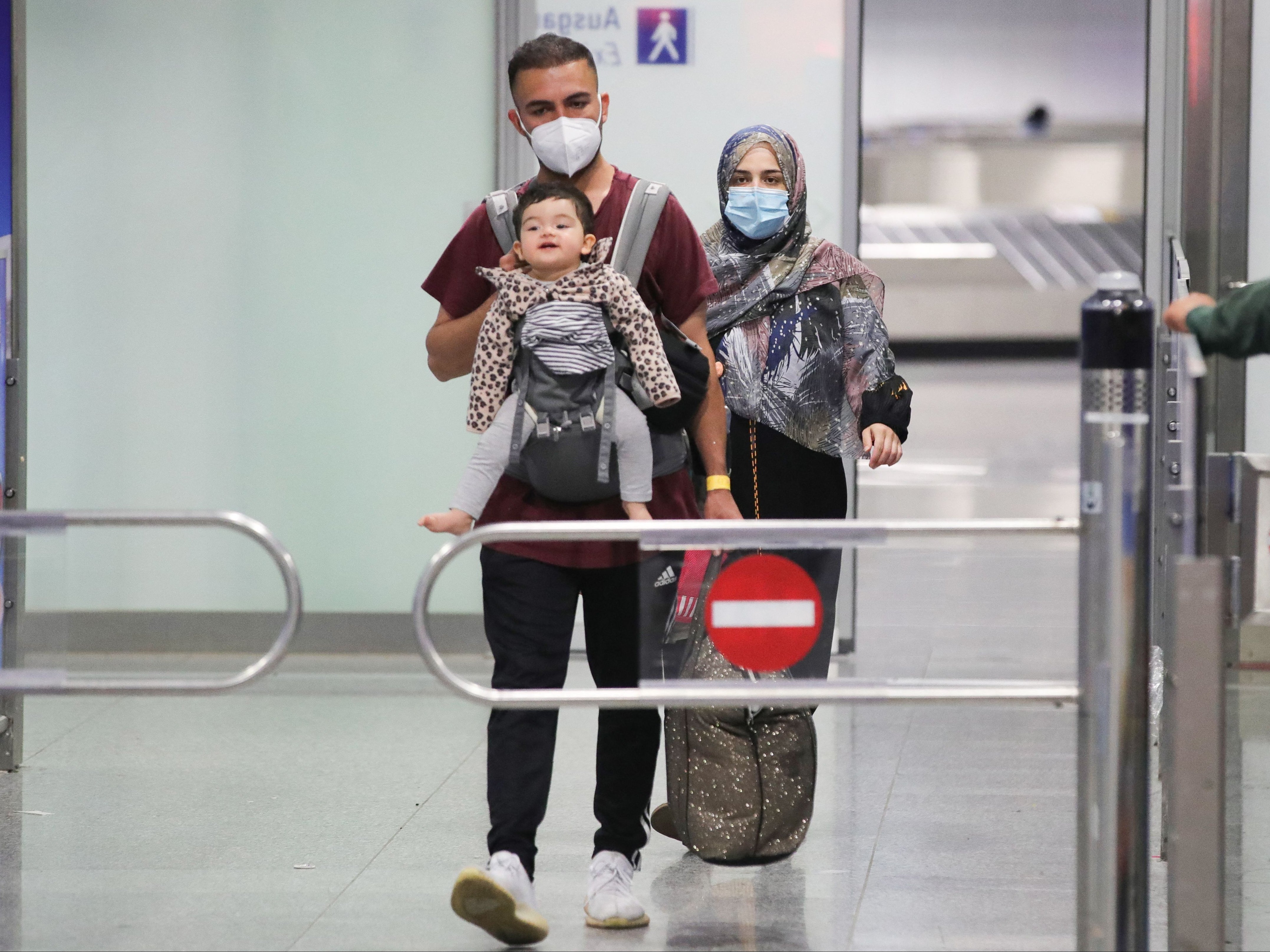 A young family who are among the first evacuees to arrive from Kabul at Frankfurt International Airport on Saturday