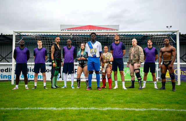Enfield Town players and WWE NXT UK wrestlers pose following the announcement of their commercial partnership (WWE)