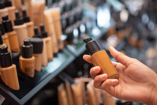 <p>A person chooses foundation at a makeup counter</p>