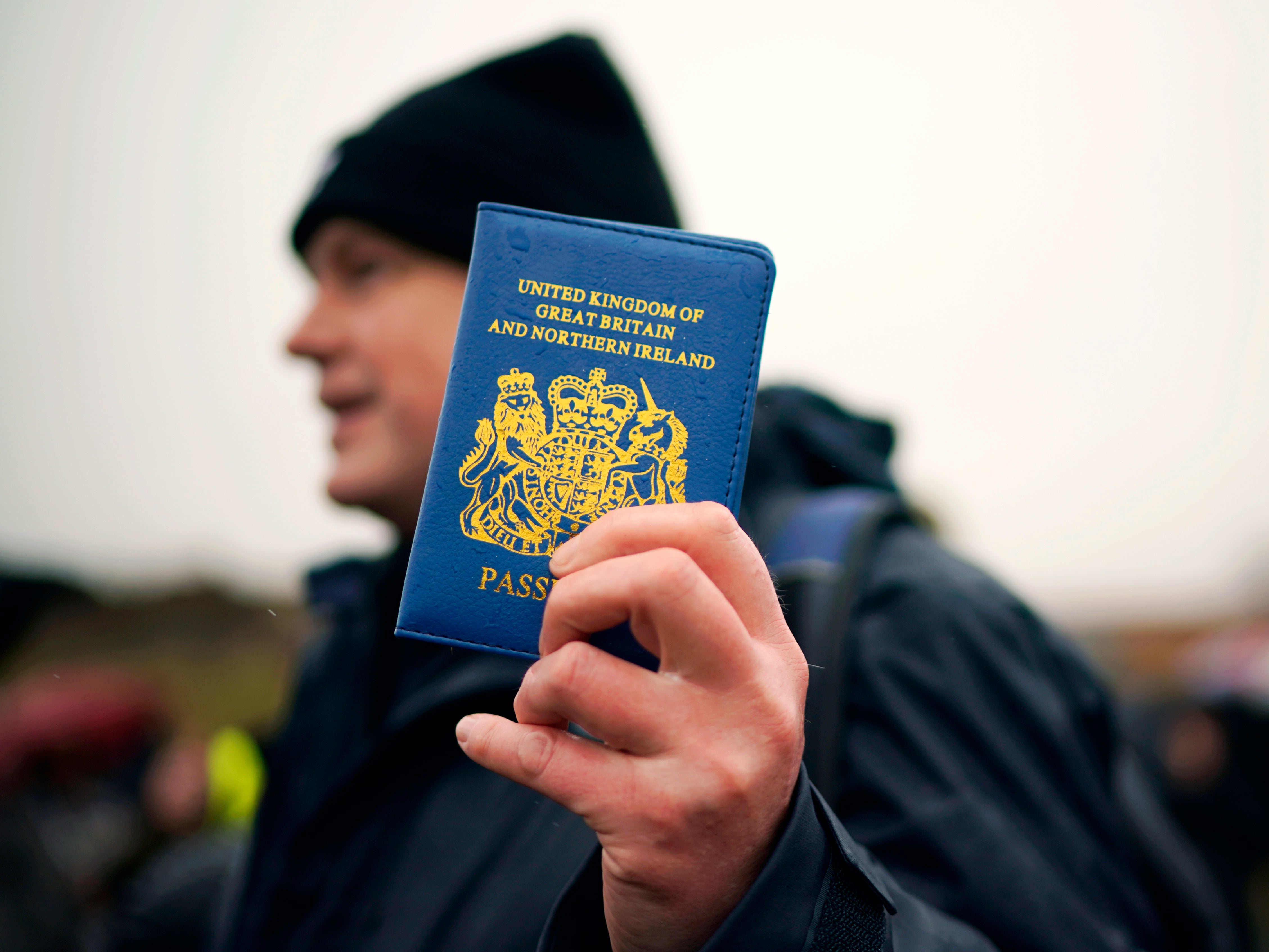 A Vote Leave supporter holds up a blue UK passport on the ‘March to Leave’ walk