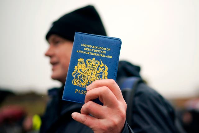 <p>A Vote Leave supporter holds up a blue UK passport on the ‘March to Leave’ walk</p>