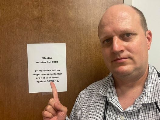 <p>Dr Jason Valentine points to his sign requiring patients to be vaccinated. </p>