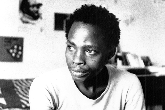 <p>Dambudzo Marechera in his flat at 8 Sloane Court, Harare, possibly 1985</p>