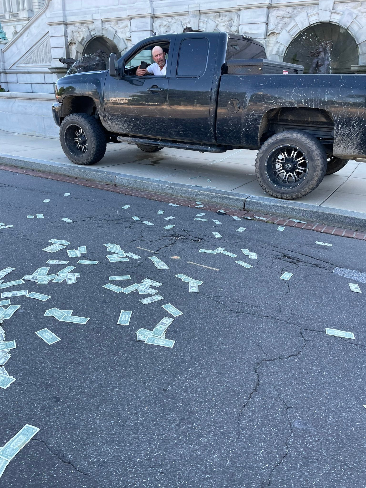 An eyewitness photo from near the Library of Congress shows the alleged suspect threatening the Capitol area with potential explosives.