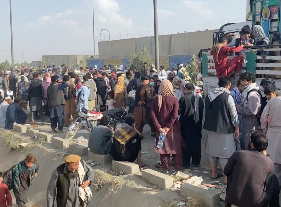 <p>Hundreds of fleeing Afghans wait outside Kabul airport on Thursday </p>
