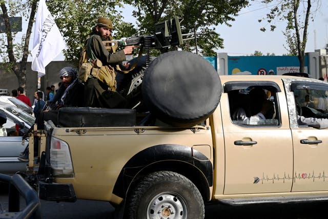 <p>Taliban fighters travel with weapons mounted on a vehicle in Kabul on August 19, 2021 after Taliban's military takeover of Afghanistan</p>