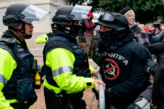 <p>A man claiming to be a member of the Proud Boys militia confronts law enforcement outside the US Capitol on January 6</p>