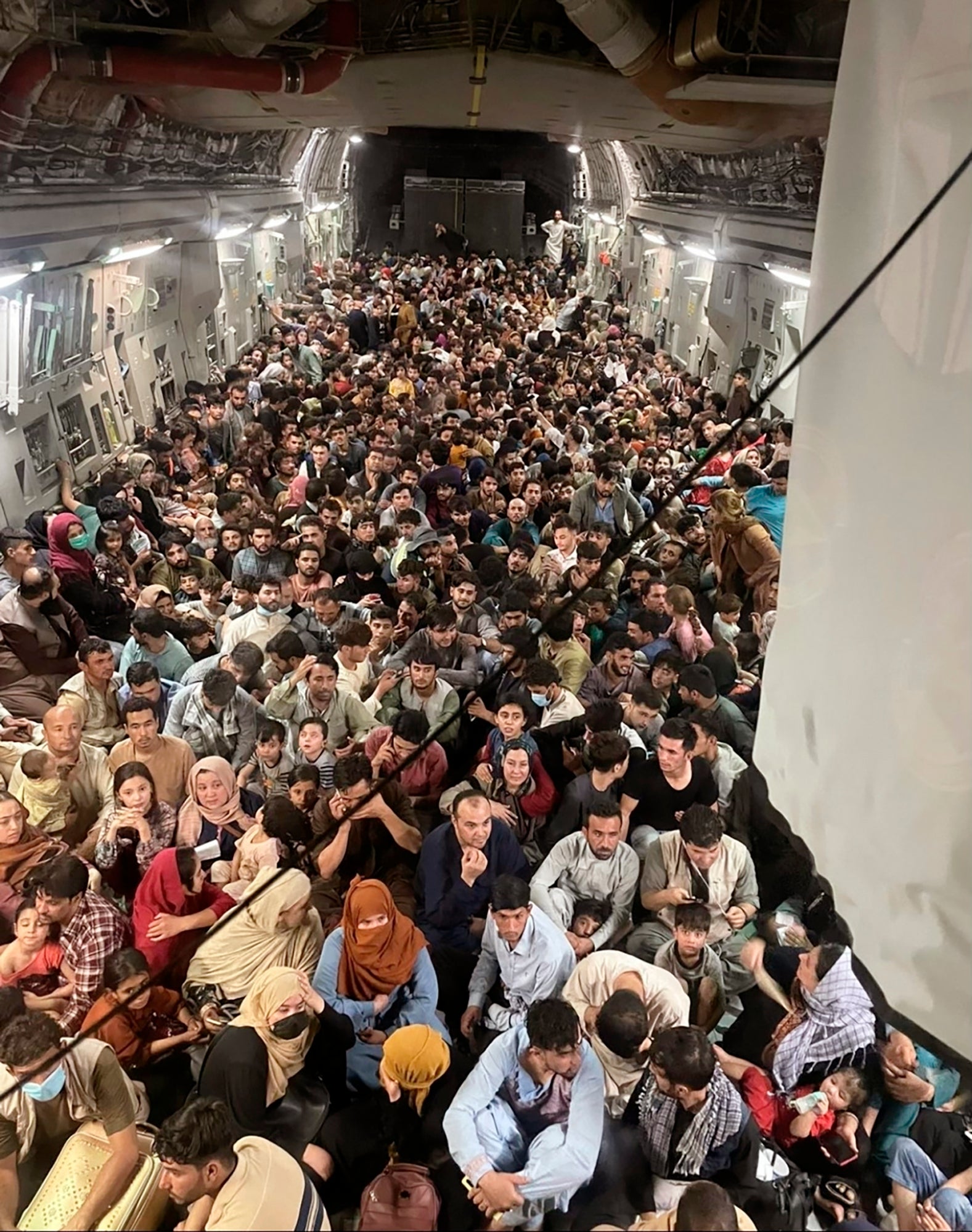 Afghan citizens pack inside a U.S. Air Force C-17 Globemaster III, as they are transported from Hamid Karzai International Airport in Afghanistan, Sunday, Aug. 15, 2021. On Friday, Aug. 20, 2021