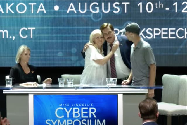 El director ejecutivo de MyPillow, Mike Lindell, abraza a la secretaria del condado de Mesa, Tina Peters, durante un "simposio cibernético" en el que se discuten las teorías de la conspiración electoral de 2020.