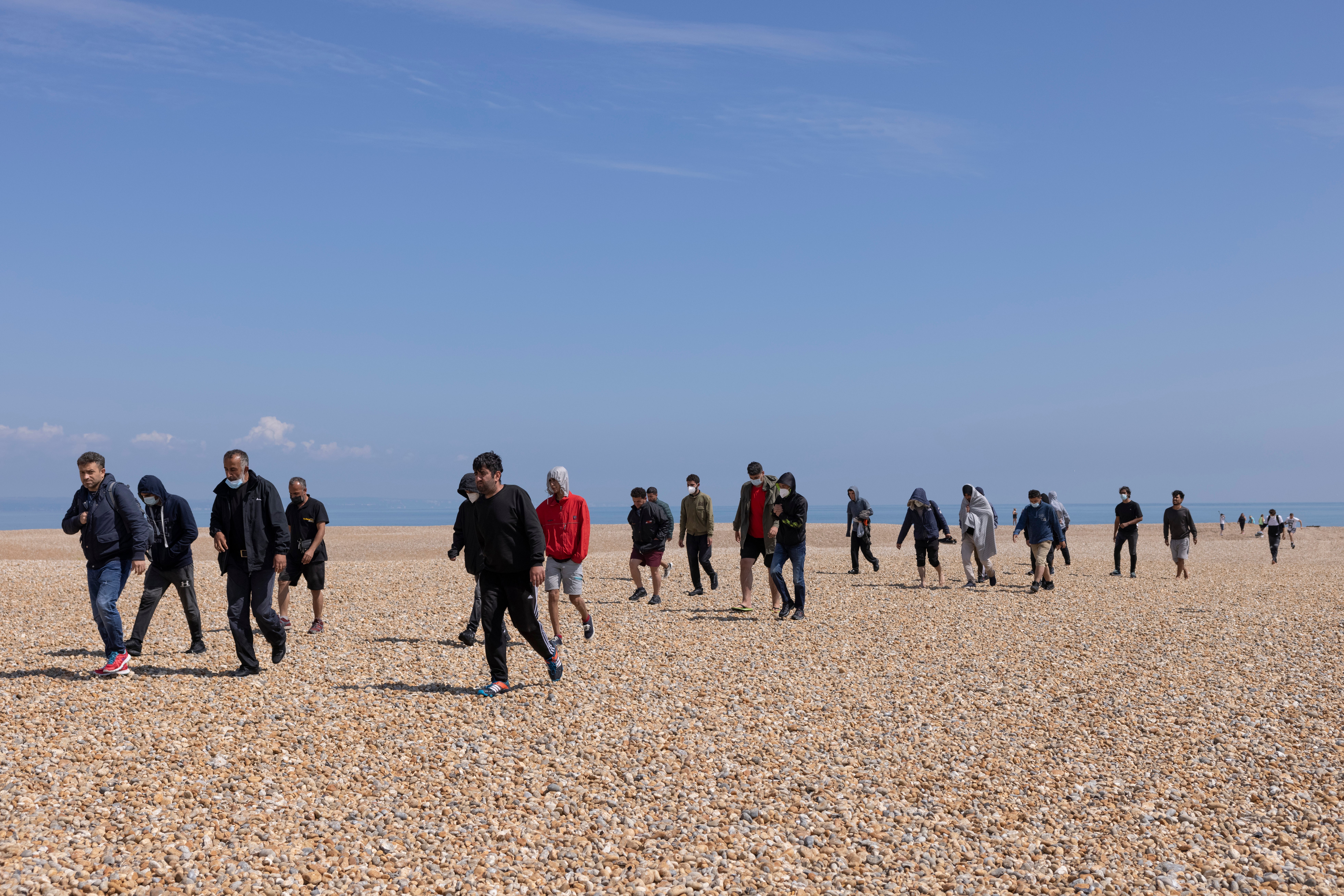 A group of around 40 migrants arrive via the RNLI on Dungeness beach