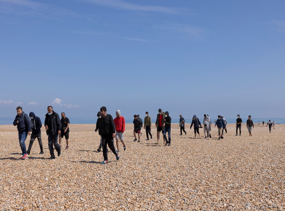 <p>A group of around 40 migrants arrive via the RNLI on Dungeness beach </p>