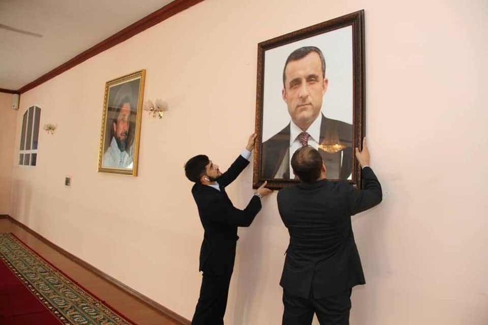 Afghan embassy staff in Dushanbe, Tajikistan, hang a portrait of Amrullah Saleh who has declared himself the ‘legitimate caretaker president’