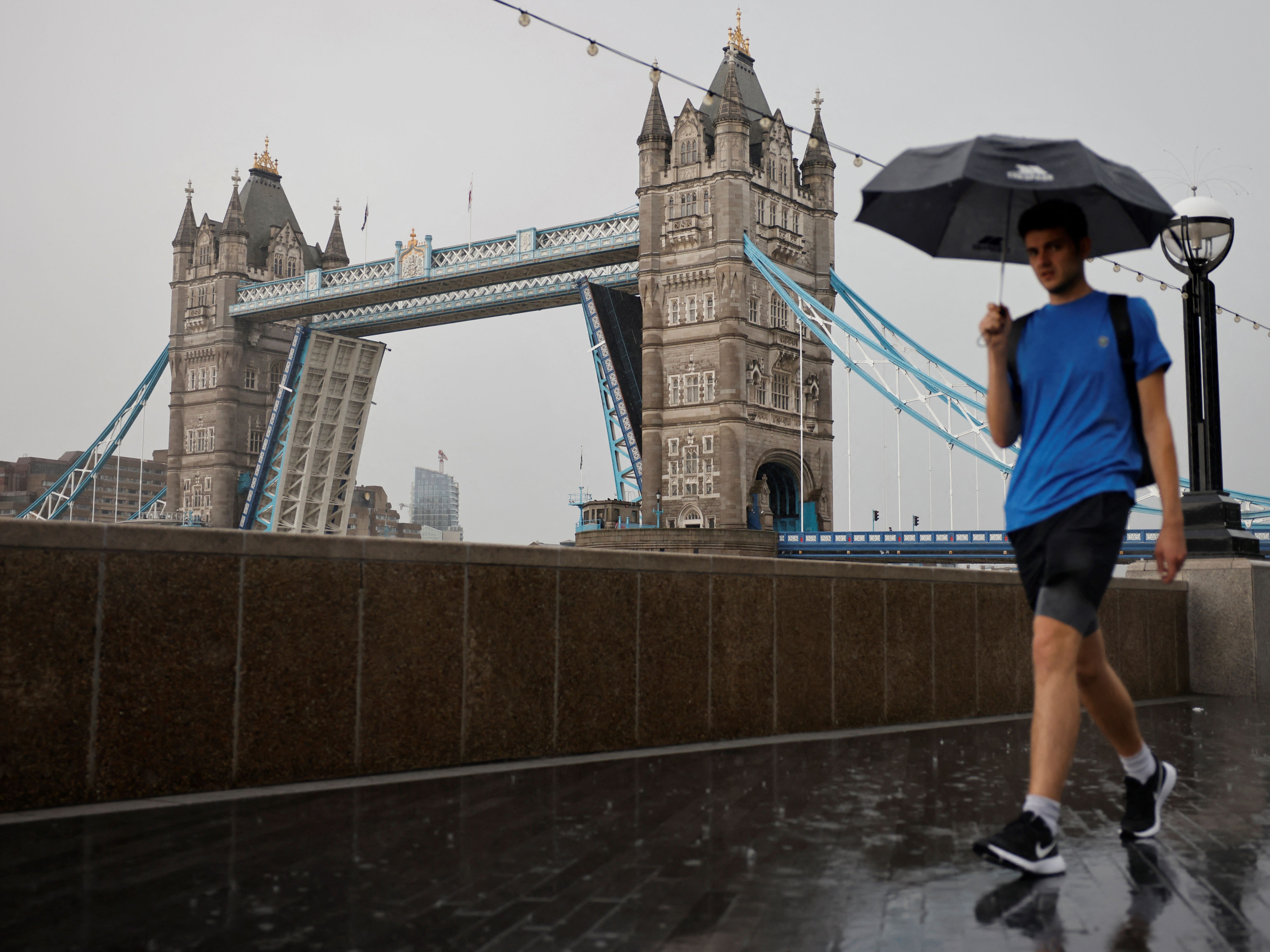 A man is pictured walking in the rain by London’s Tower Bridge earlier this month