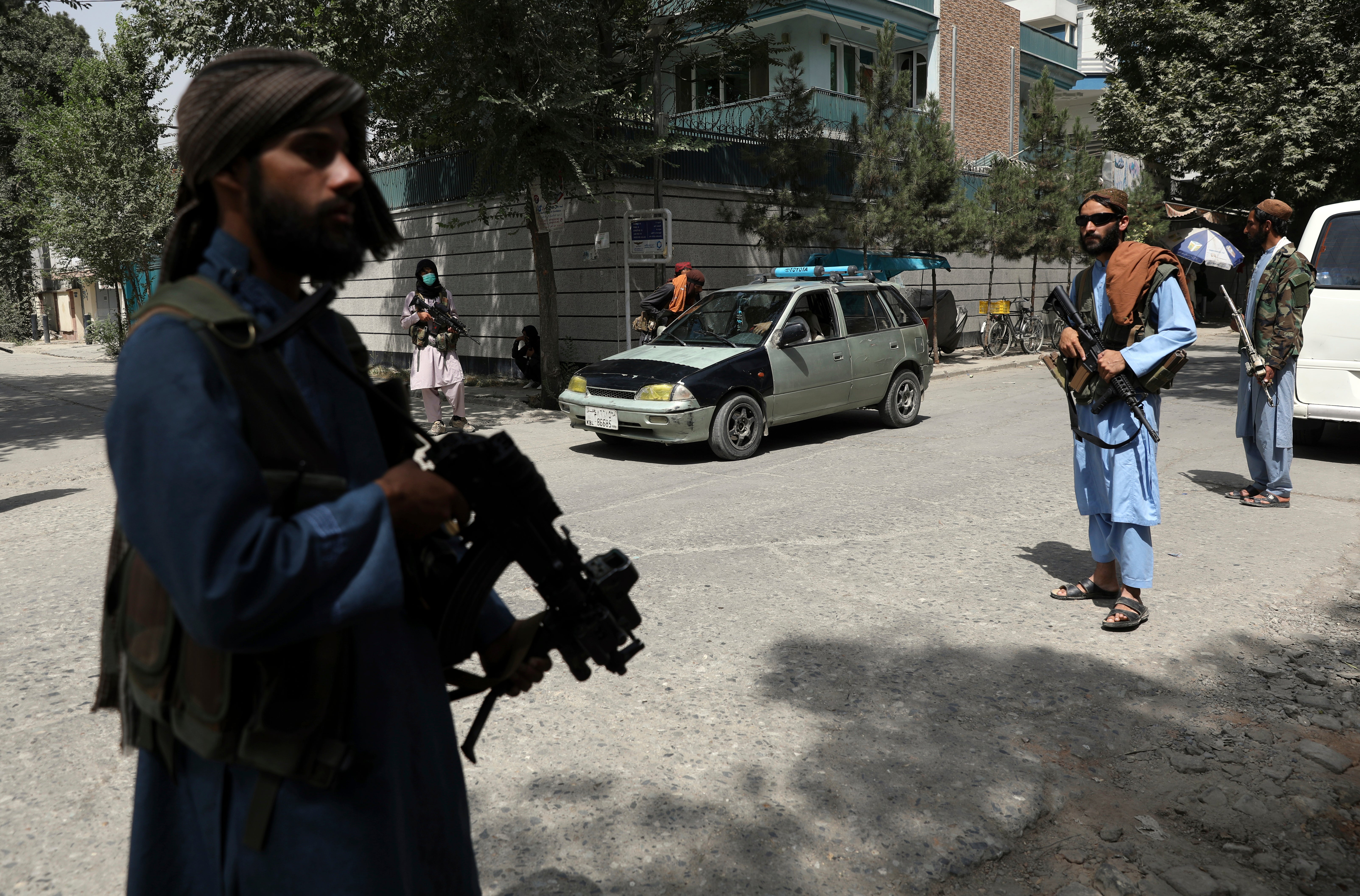 Taliban fighters stand guard at a checkpoint in the Wazir Akbar Khan neighborhood in the city of Kabul