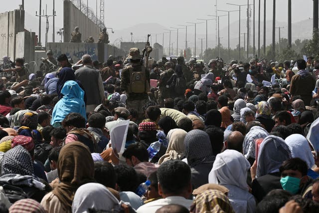 <p>File: Afghans gather on a roadside near the Kabul airport on 20 August 2021, hoping to flee from Taliban rule in the country </p>
