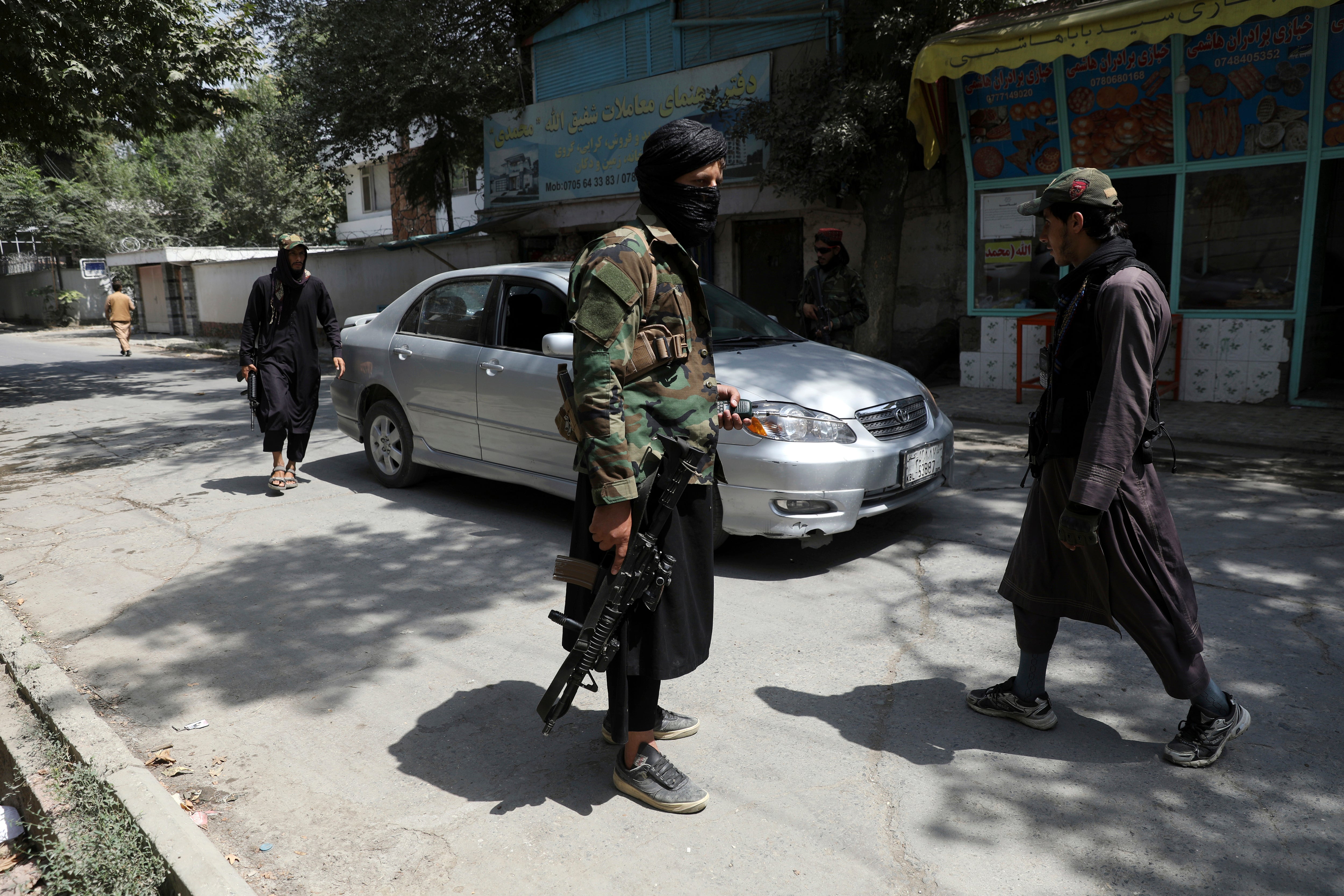 Taliban fighters stand guard at a checkpoint in the Wazir Akbar Khan neighborhood in Kabul