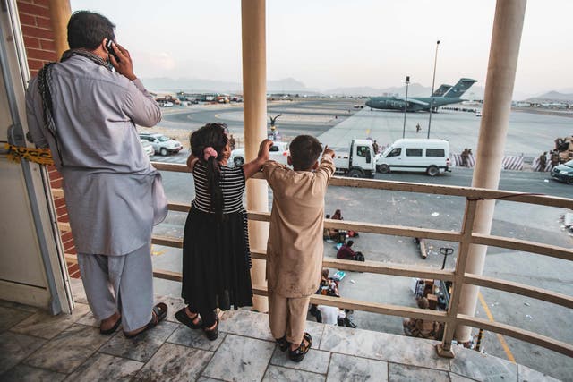 <p>In this image courtesy of the US Marine Corps, two children point at an aircraft at Kabul’s Hamid Karzai International Airport</p>