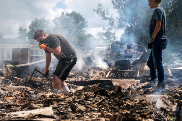 <p>Josh Whitlock and Stacy Mathieson look through what is left of their home after it burned following flooding in Waverly, Tennessee</p>