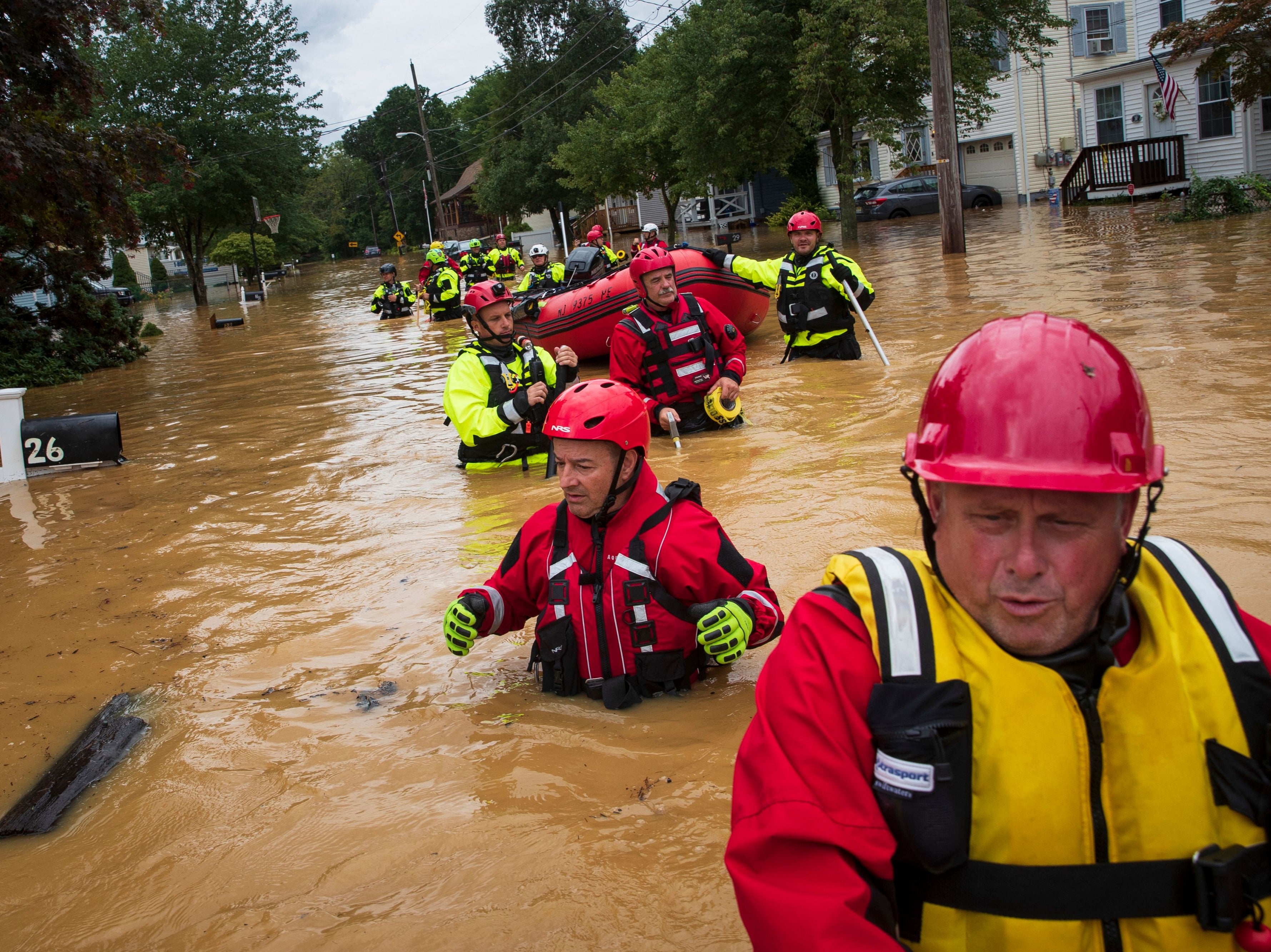 Members of the New Market Volunteer Fire Company perform a secondary search during an evacuation effort following a flash flood, as Tropical Storm Henri makes landfall, in Helmetta, New Jersey