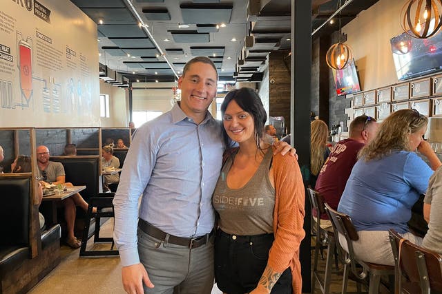 <p>Ohio-based Senate candidate Josh Mandel poses with a server at a restaurant in Perrysburg, Ohio, on Friday, 20 August, 2021. Mr Mandel caused controversy by praising the server on social media for working while sick. </p>