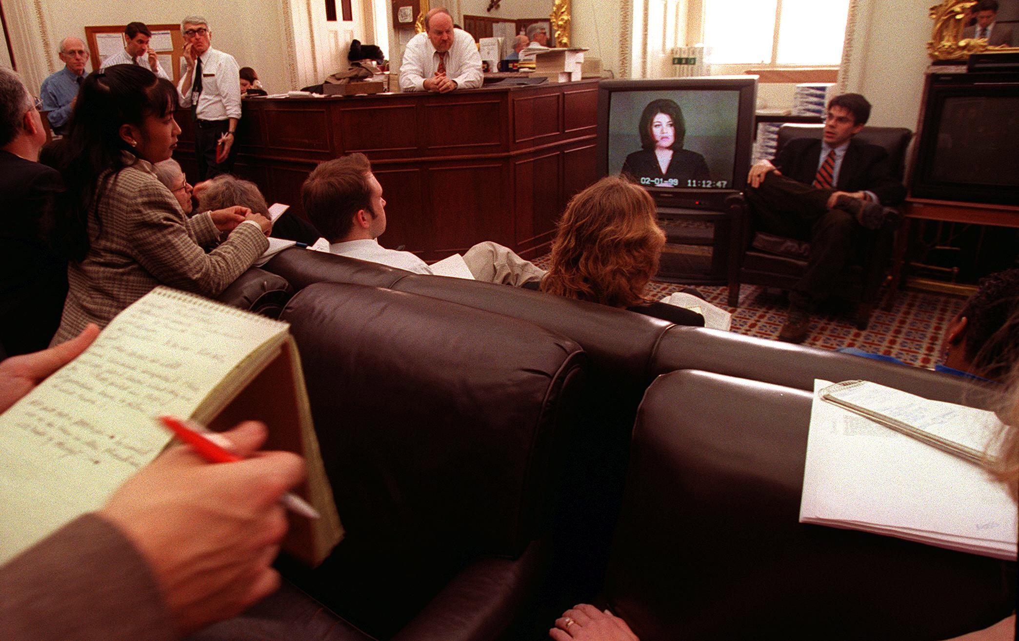 Reporters in a press room in the US Capitol watch as the videotaped testimony of Monica Lewinsky is played in the US Senate during the impeachment trial of President Bill Clinton on 6 February 1999