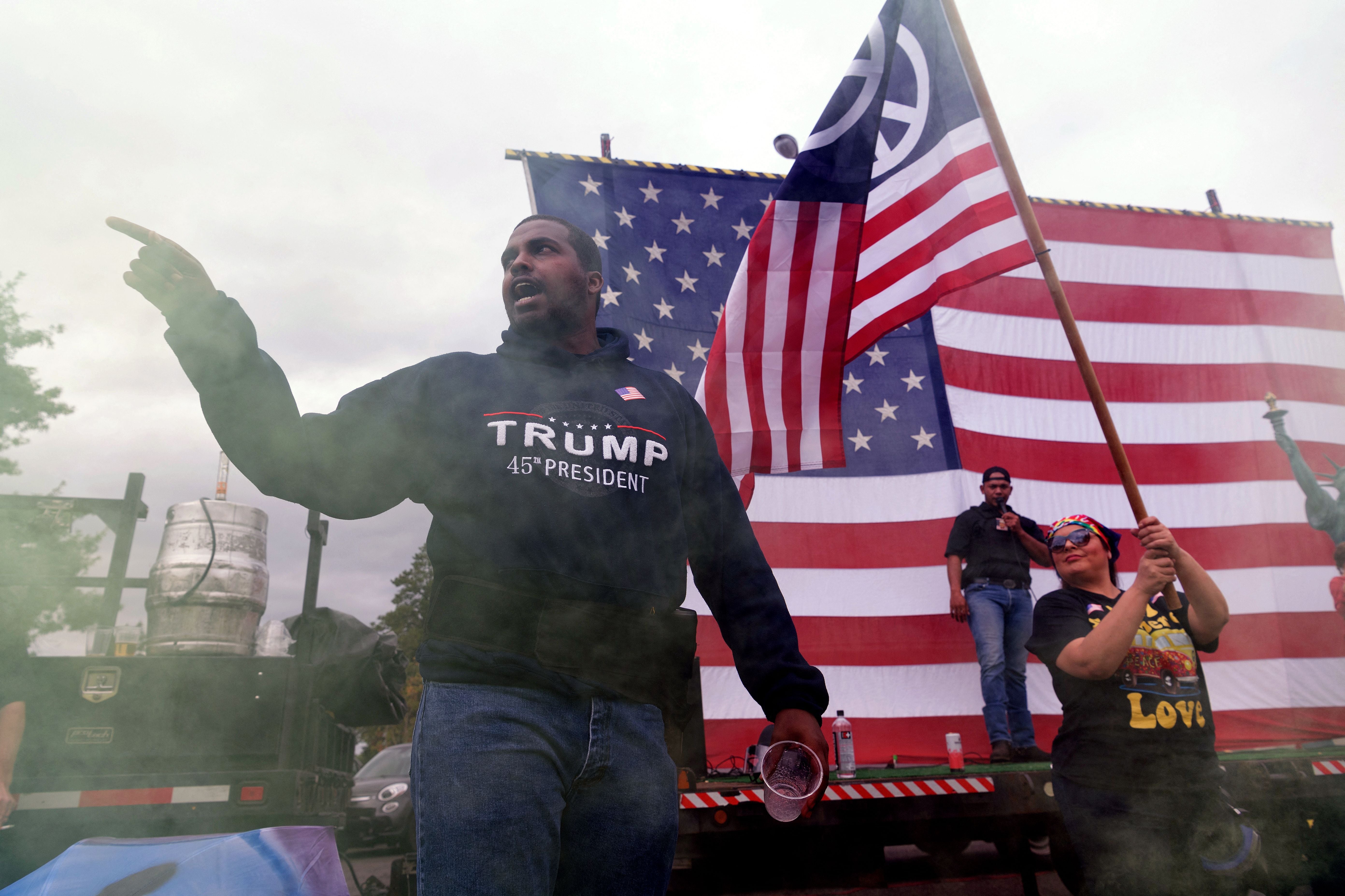 Right-Wing activist Phillip Anderson (L) gives a speech while shrouded in yellow smoke during a far-right rally on August 22, 2021 in Portland, Oregon. - Far-right groups, including the Proud Boys held a rally in Portland on the anniversary of a violent altercation with anti-fascist activist a year earlier.