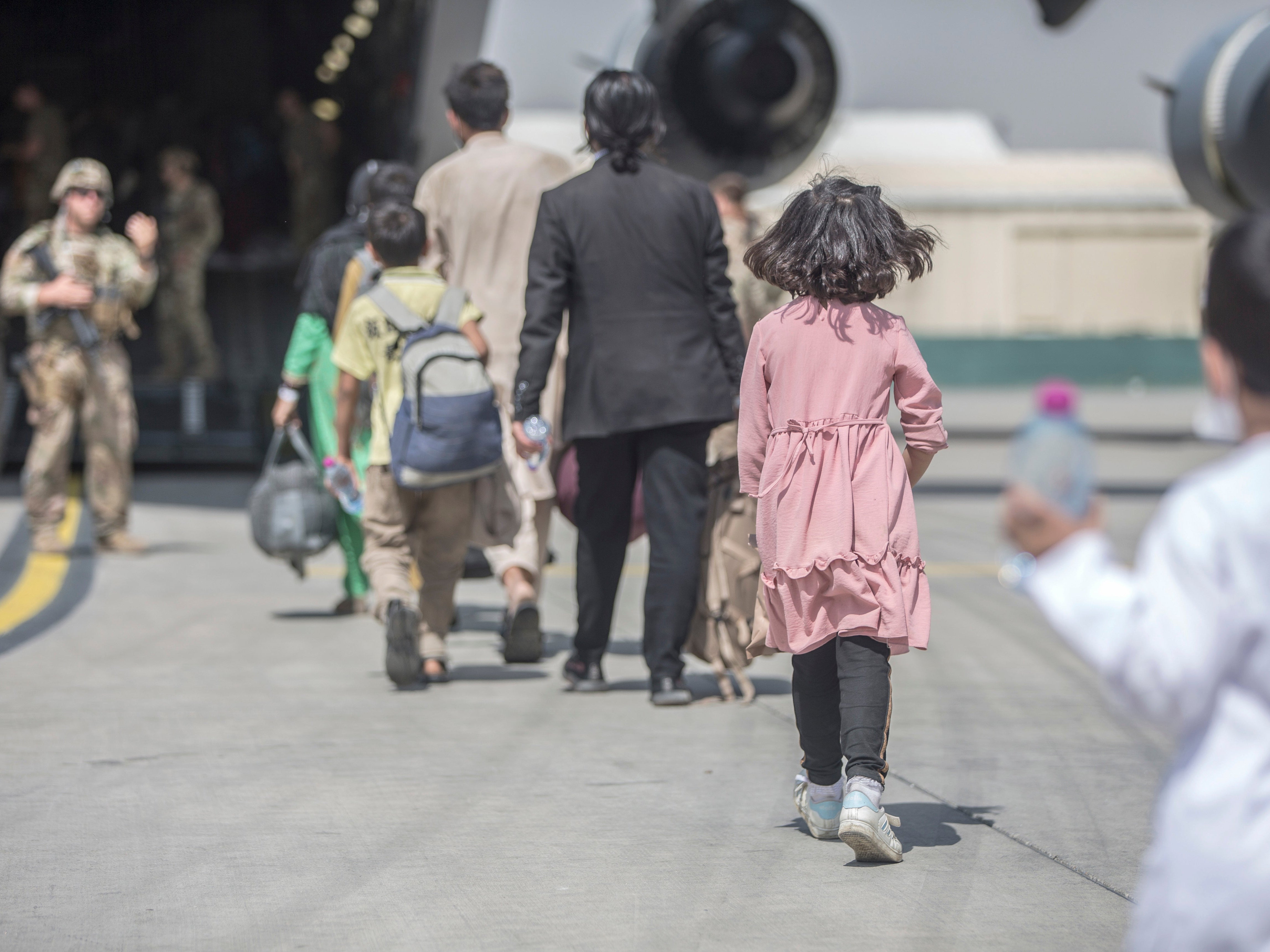 Families board a plane during an evacuation at Hamid Karzai International Airport in Kabul last month
