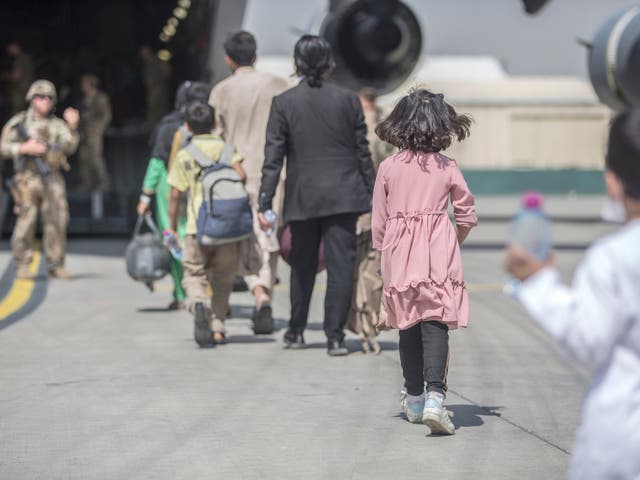 <p>Families board a plane during an evacuation at Hamid Karzai International Airport in Kabul last month </p>