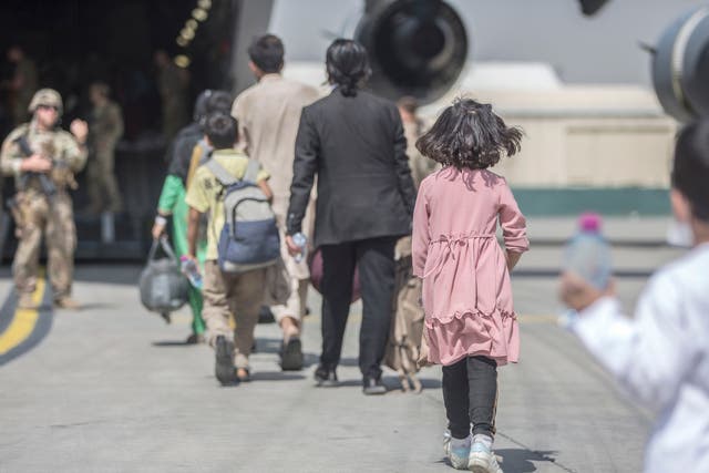 <p>Families board a plane during an evacuation at Hamid Karzai International Airport in Kabul last month </p>