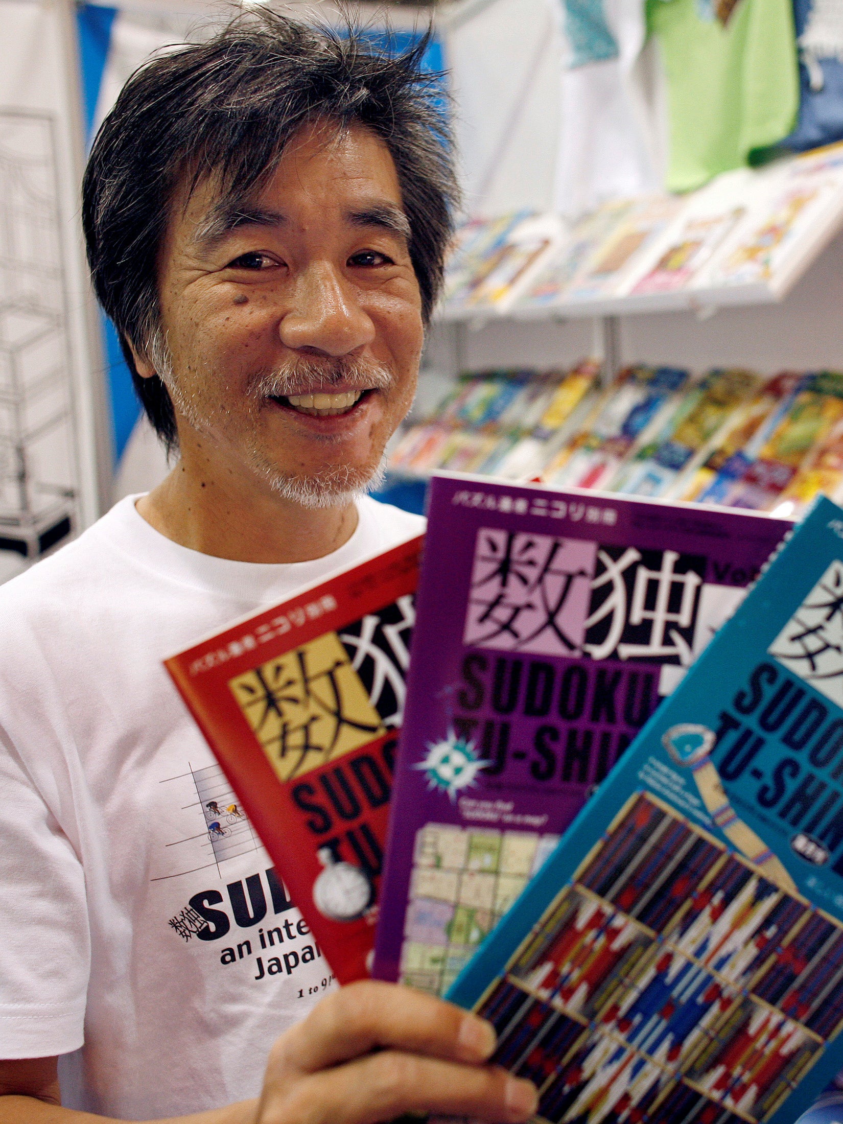 Kaji holds copies of the latest sudoku puzzles at the Book Expo, in New York, June 2007