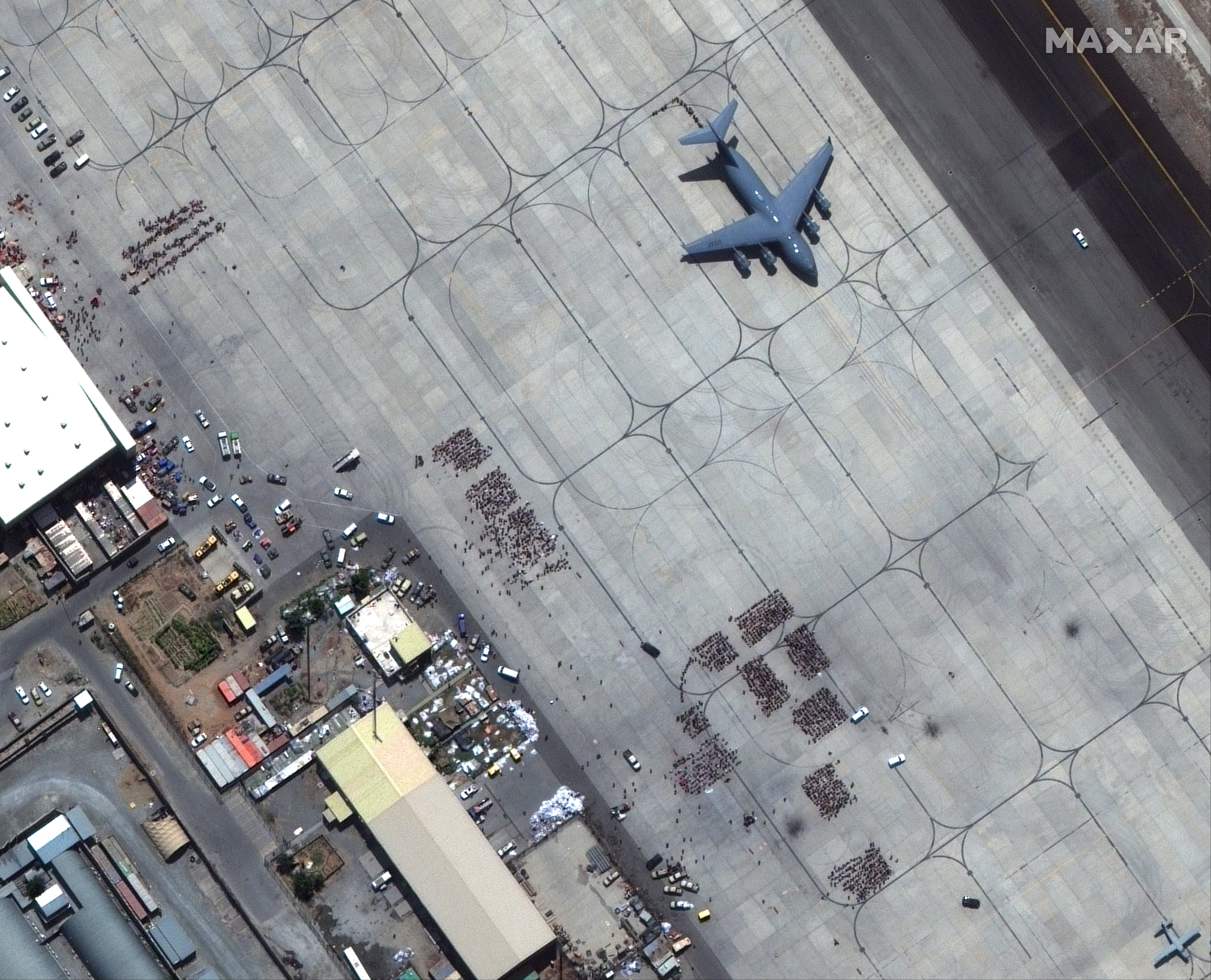 A satellite image shows groups of people waiting on the tarmac at Kabul Airport in Kabul, Afghanistan, 23 August 2021