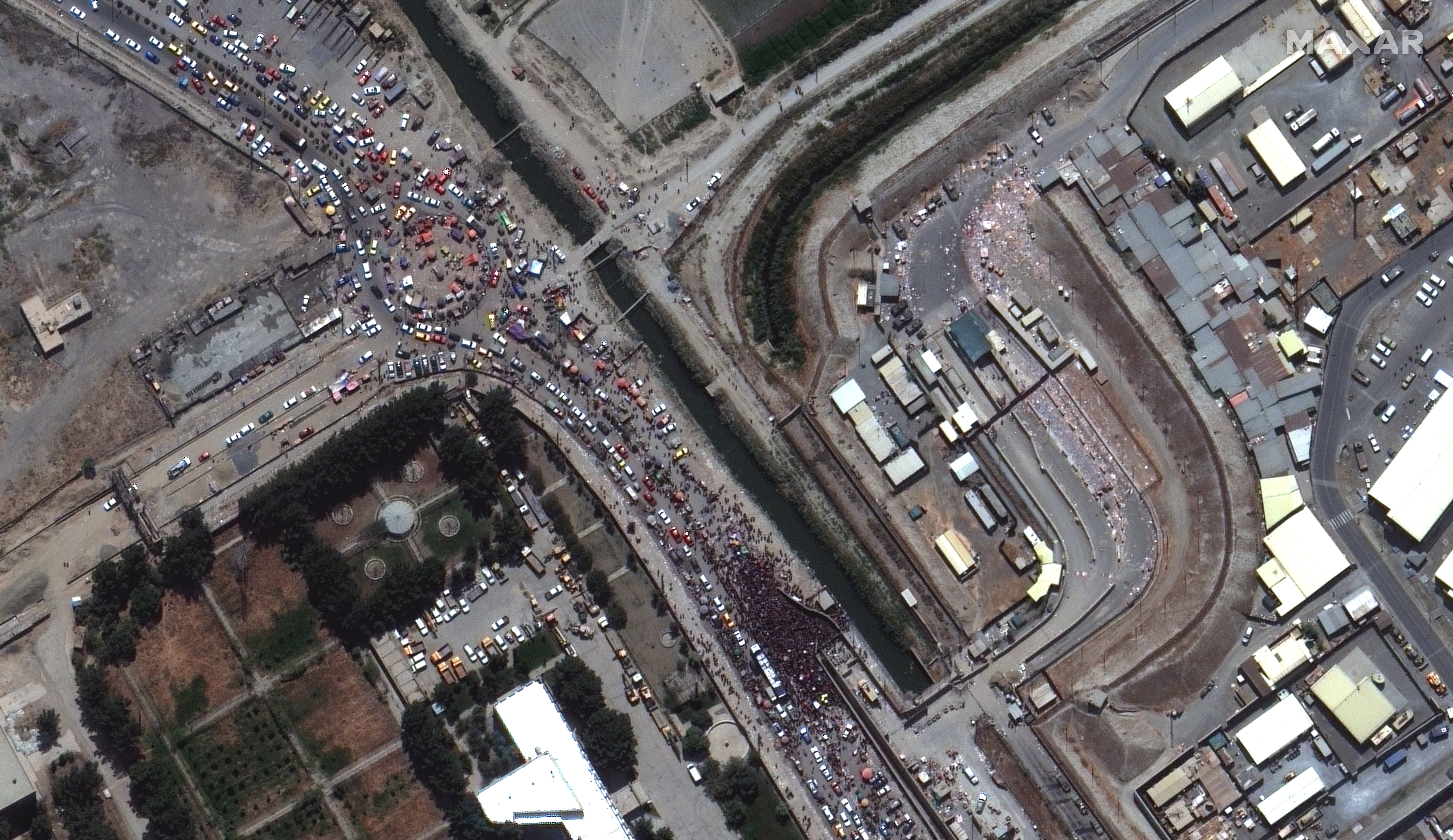 A satellite image shows large crowds gathered at the northern edge of Kabul Airport in Kabul, Afghanistan, 23 August 2021