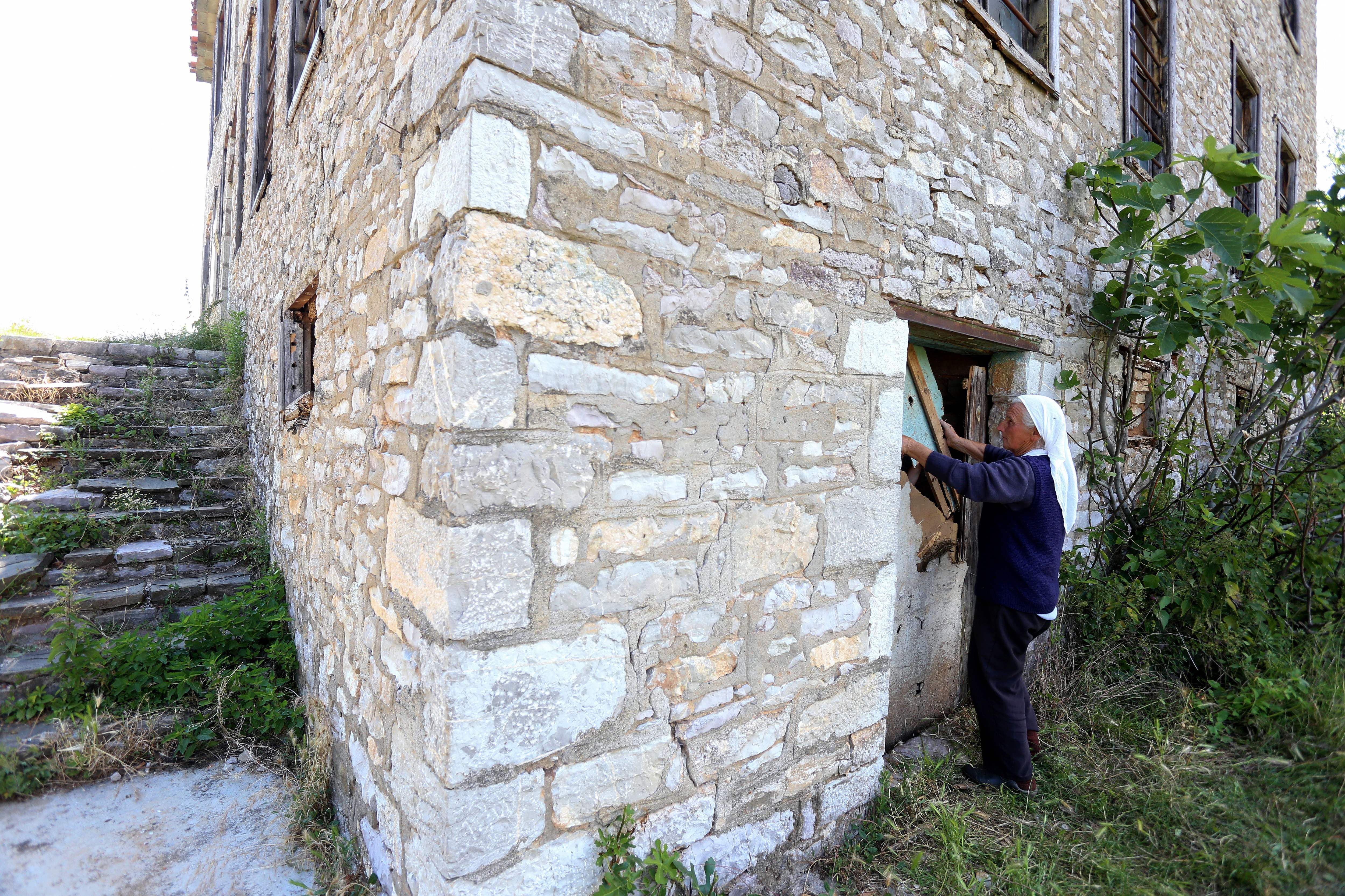 Sabire Plaku closes the door of the basement housing the statue