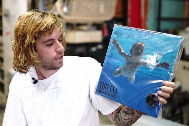 <p>Spencer Elden posing with the cover of Nirvana’s ‘Nevermind’ </p>