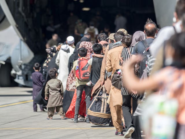 <p>Families board a US flight at Hamid Karzai International Airport in Kabul</p>