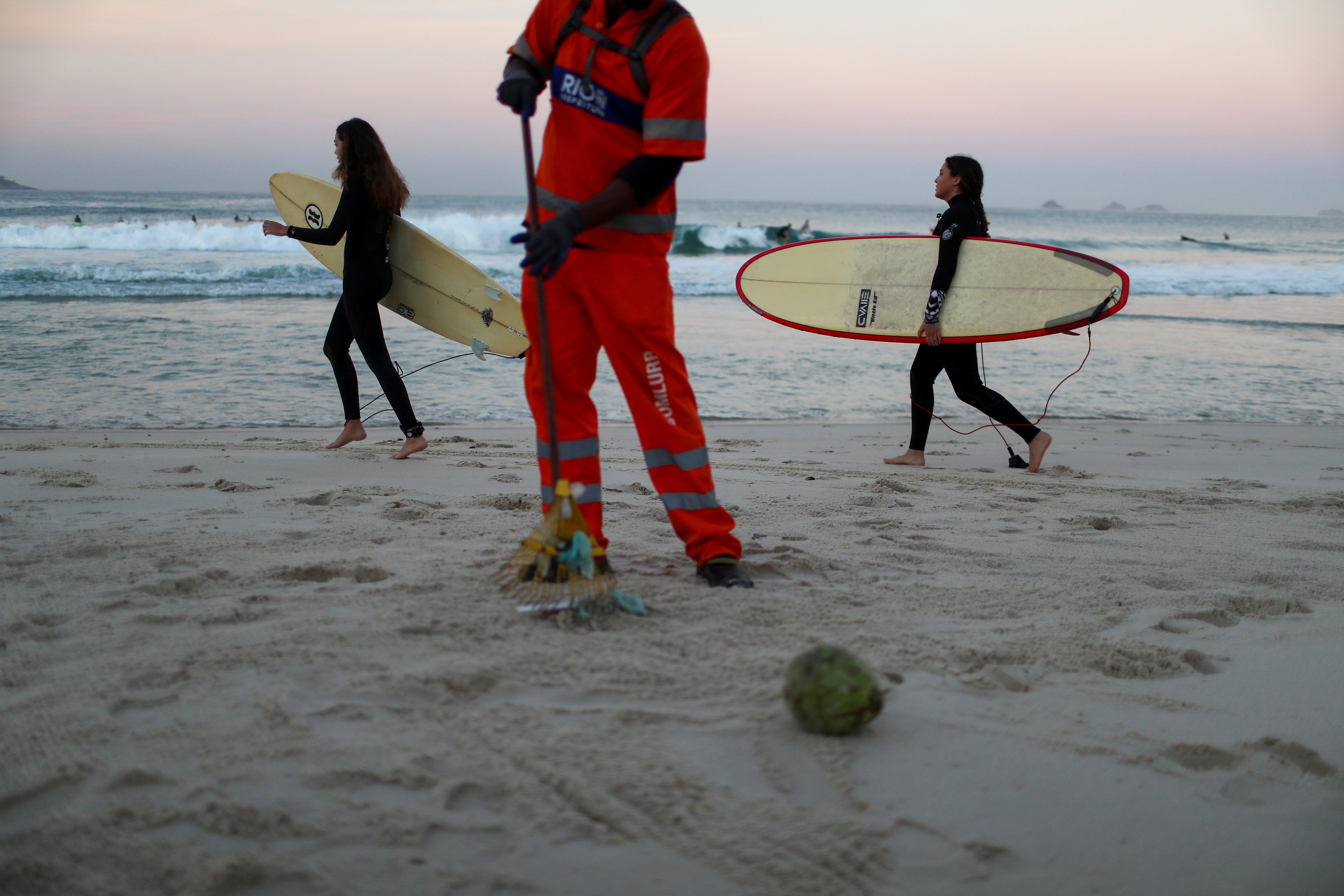 Felipe picking up the rubbish that sunbathers have left on the sand