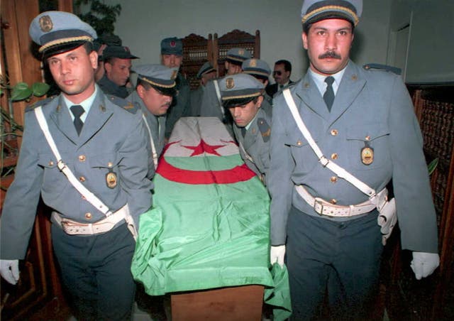 <p>Police carry the coffin of Rachida Hammadi, a television reporter, flown back to Algiers for burial. She died after an    attack by Islamic extremists</p>