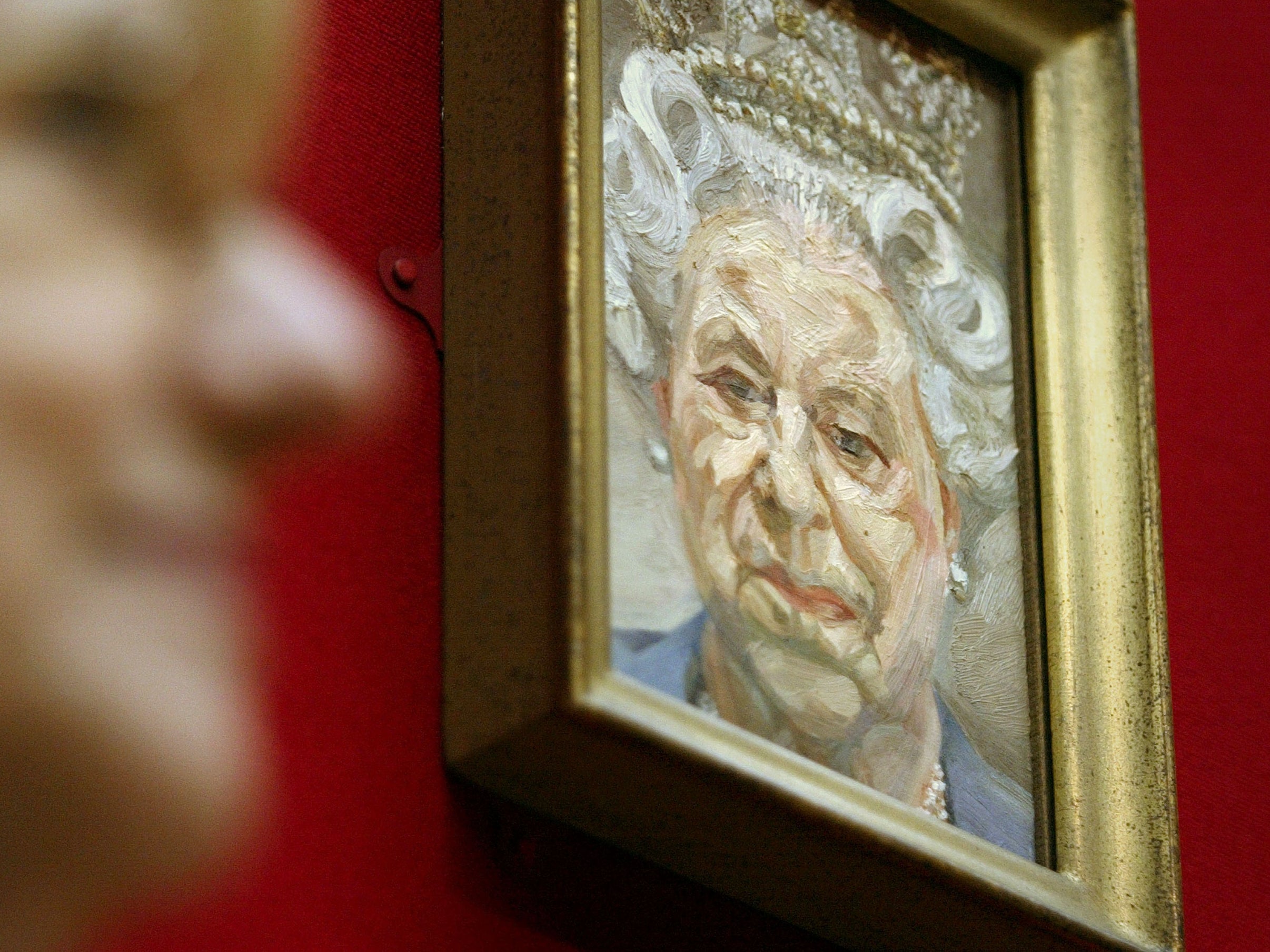 A gallery visitor walks by a newly unveiled portrait of the queen by British artist Lucien Freud at the inaugural opening of the Royal Collection at the Queen’s Gallery in Buckingham Palace in 2002