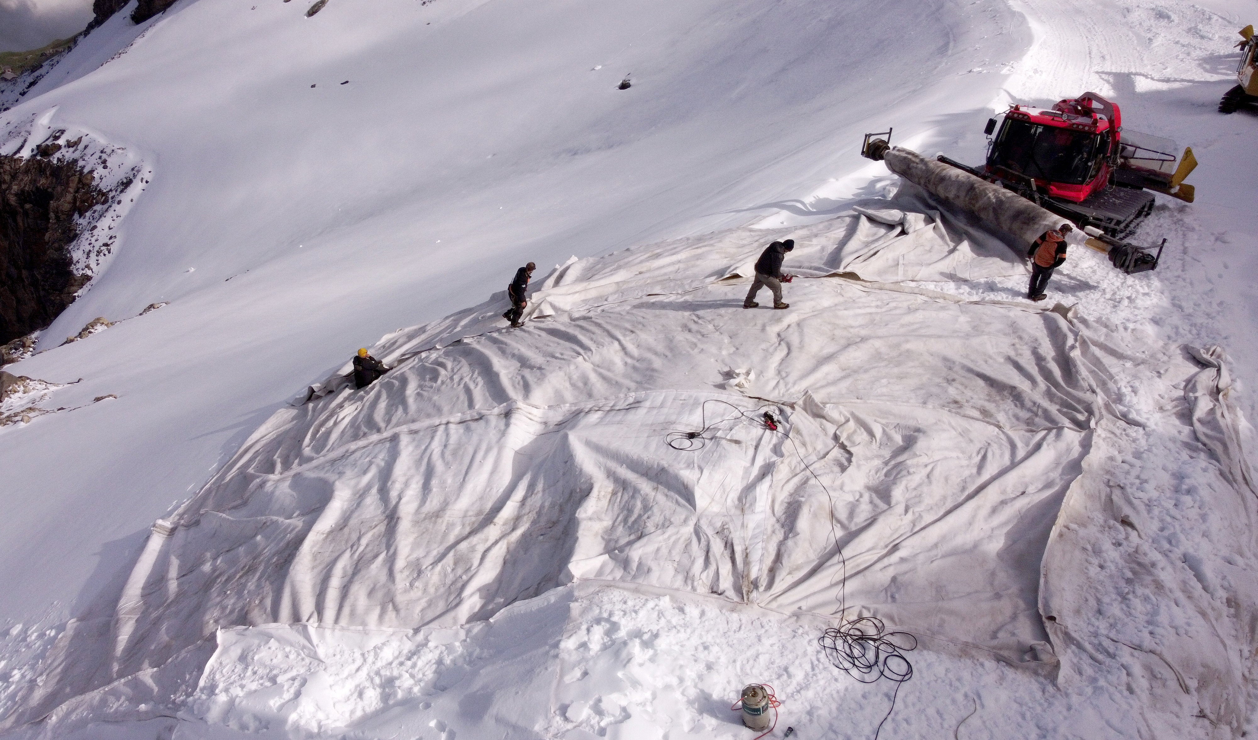 Employees place blankets on parts of the glacier to protect it against melting