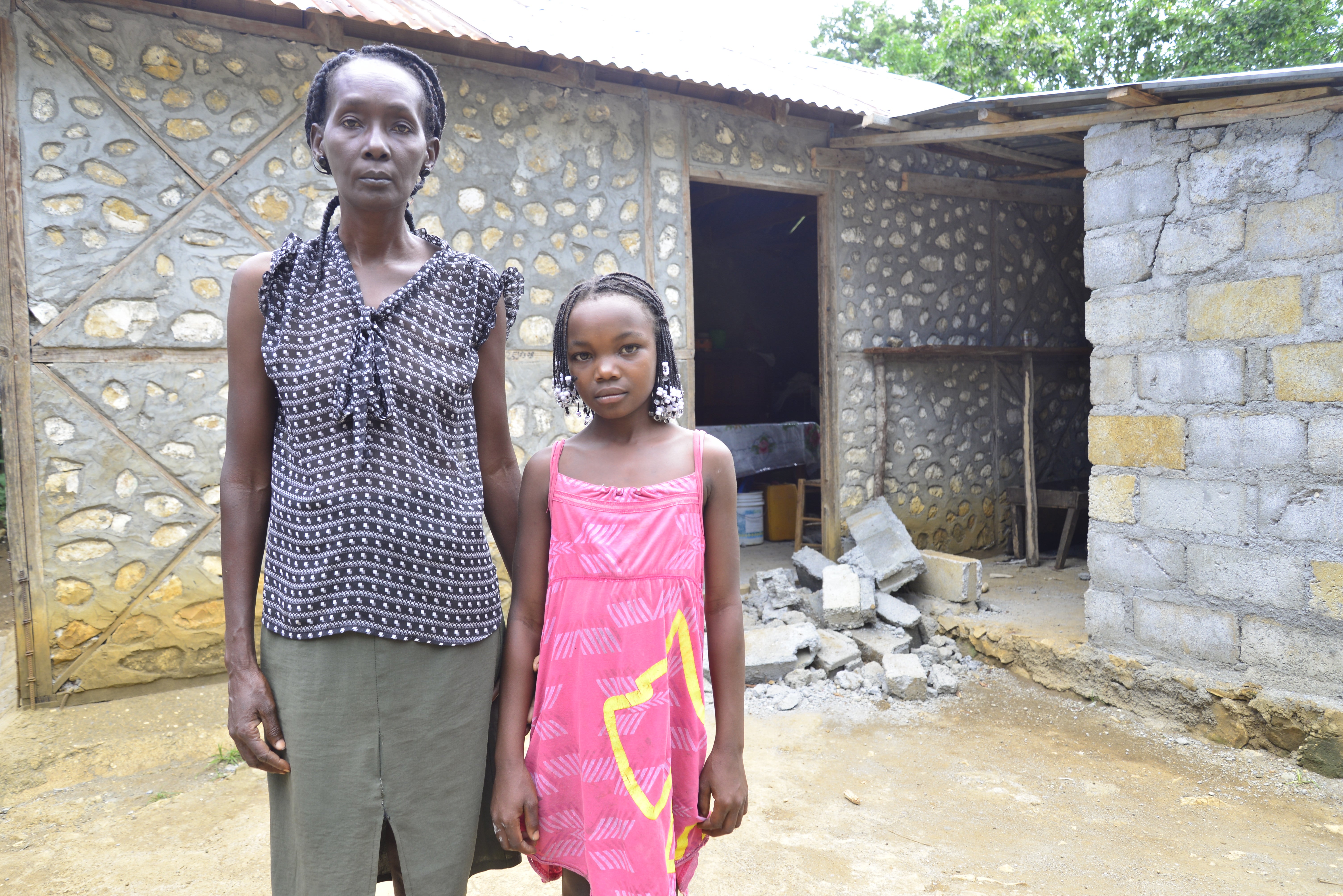 Paulène and her daughter Natalie, in front of their house destroyed by the earthquake