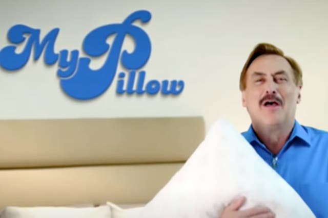 <p>Mike Lindell, the CEO of MyPillow, hugs one of his pillows in a television advertisement.</p>