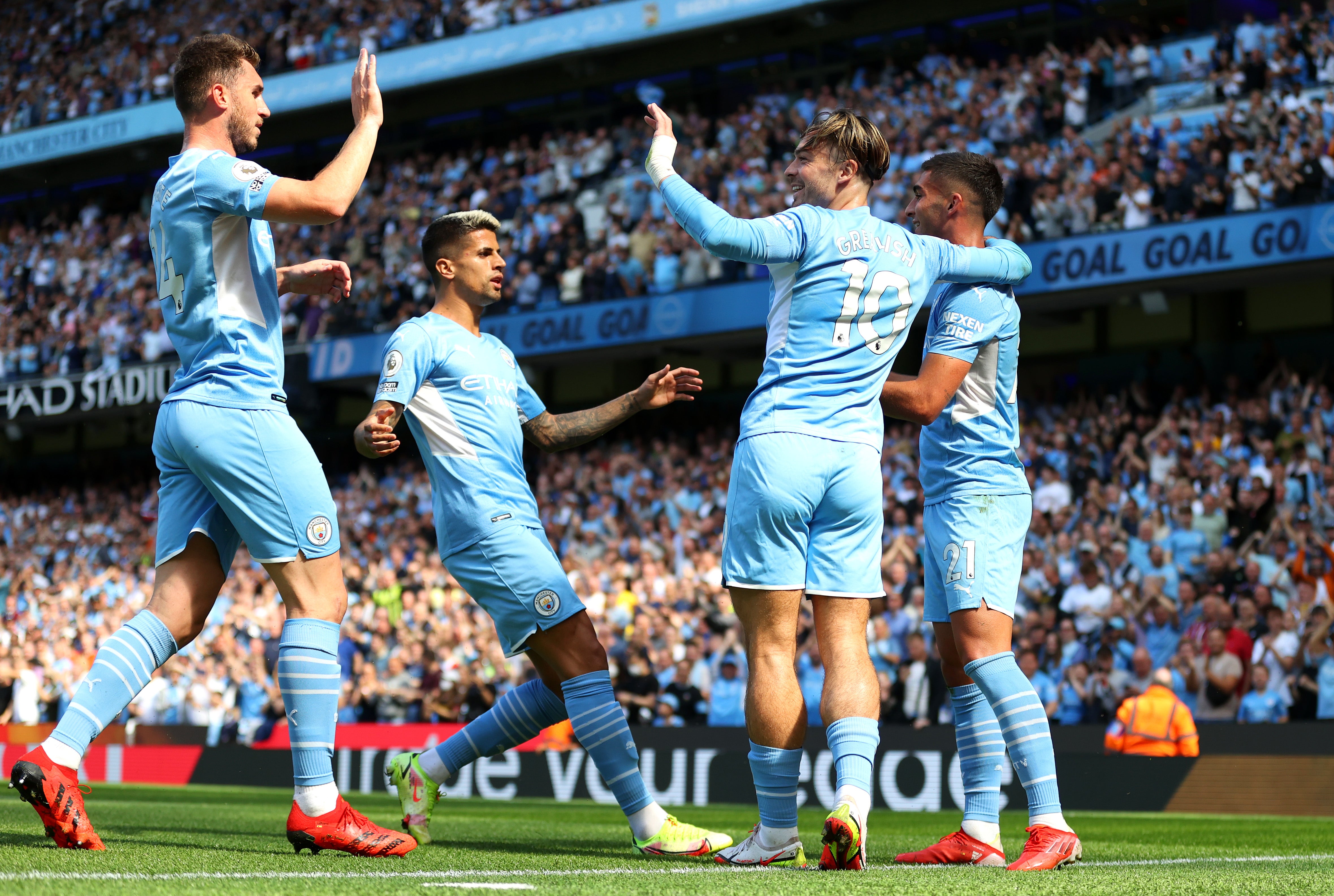Ferran Torres of Manchester City celebrates with teammates Aymeric Laporte, Joao Cancelo, and Jack Grealish