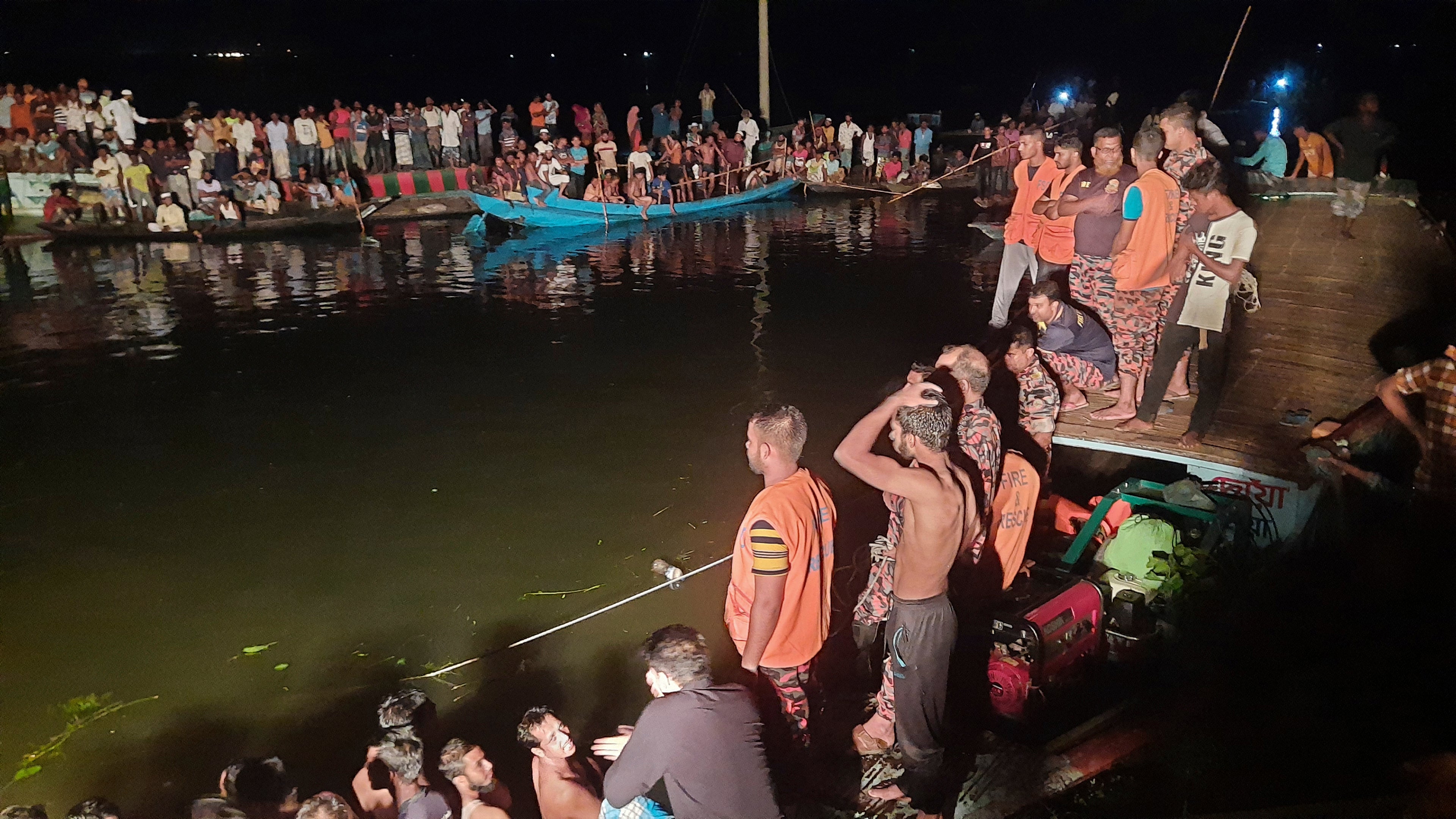 People watch rescue workers after a passenger boat sank in Brahmanbaria district, Bangladesh