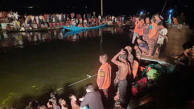 <p>People watch rescue workers after a passenger boat sank in Brahmanbaria district, Bangladesh</p>